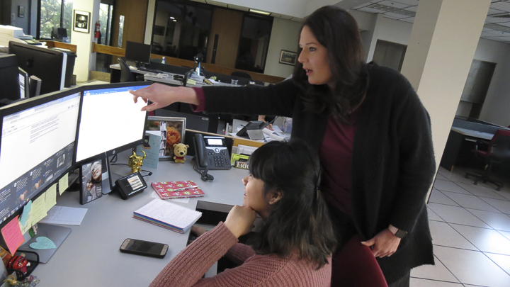 Monique Batson, city editor and web producer for the Beaumont Enterprise, right, assists Erica Apodaca, reporter, with gathering police reports for the morning news, Friday, at the Beaumont Enterprise. UP photo by Olivia Malick