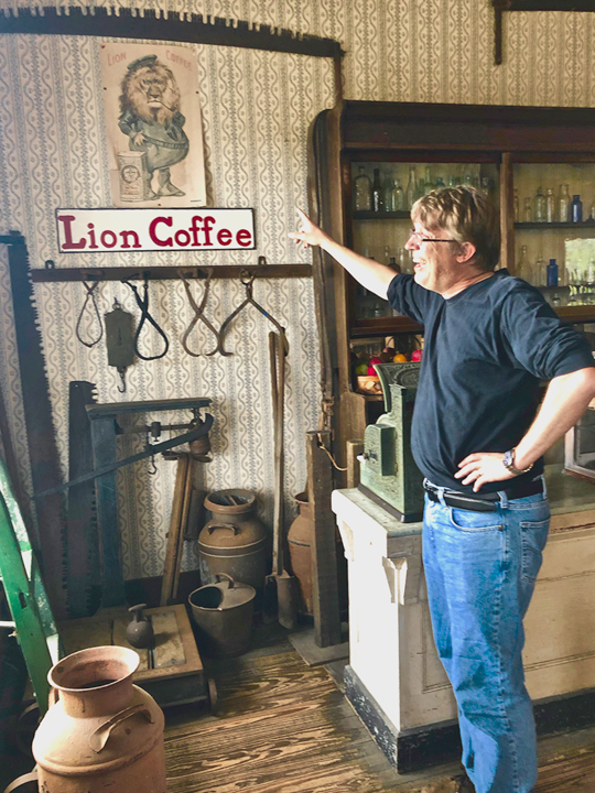 Spindletop director Troy Gray shows the Lion Coffee poster in the general store at Spindletop Gladys City Boomtown Museum, Friday. UP photo by Vy Nguyen