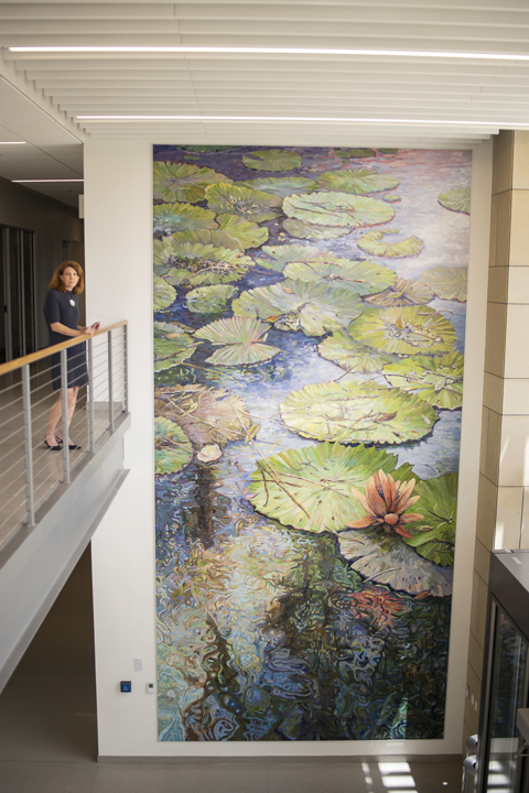 Kim Steinhagen, co-chair of Lamar’s Public Art Committee, above, stands next to the 25 feet by 12 feet mosaic mural by Dixie Friend Gay, in the Science and Technology building. UP photos by Noah Dawlearn