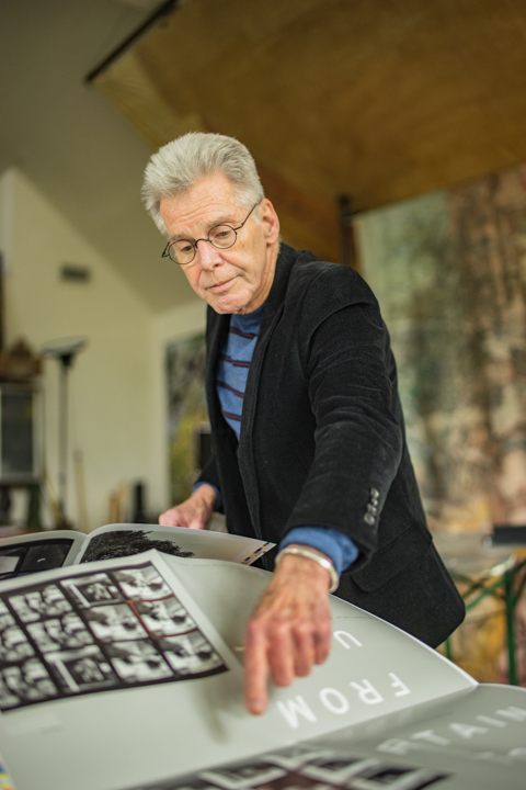Carter flips through the original prints of his first book, “From Uncertain to Blue,” a book that helped him find his personal style as a photographer and included photos from 100 unusual places in Texas. UP photo by Noah Dawlearn