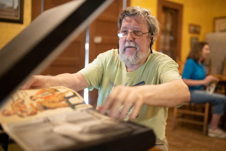 Steven Lewis, Lamar University alumnus, scans an old football program inside of Spindletop Gladys City Boomtown Museum, Saturday.