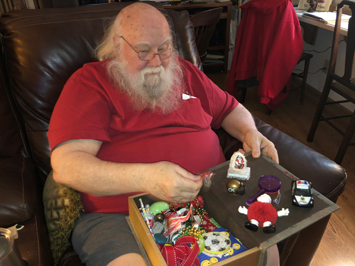 Spinney, top, in his Santa gear at Parkdale Mall. Spinney keeps a collection of all the gifts children have given him over the years, above.