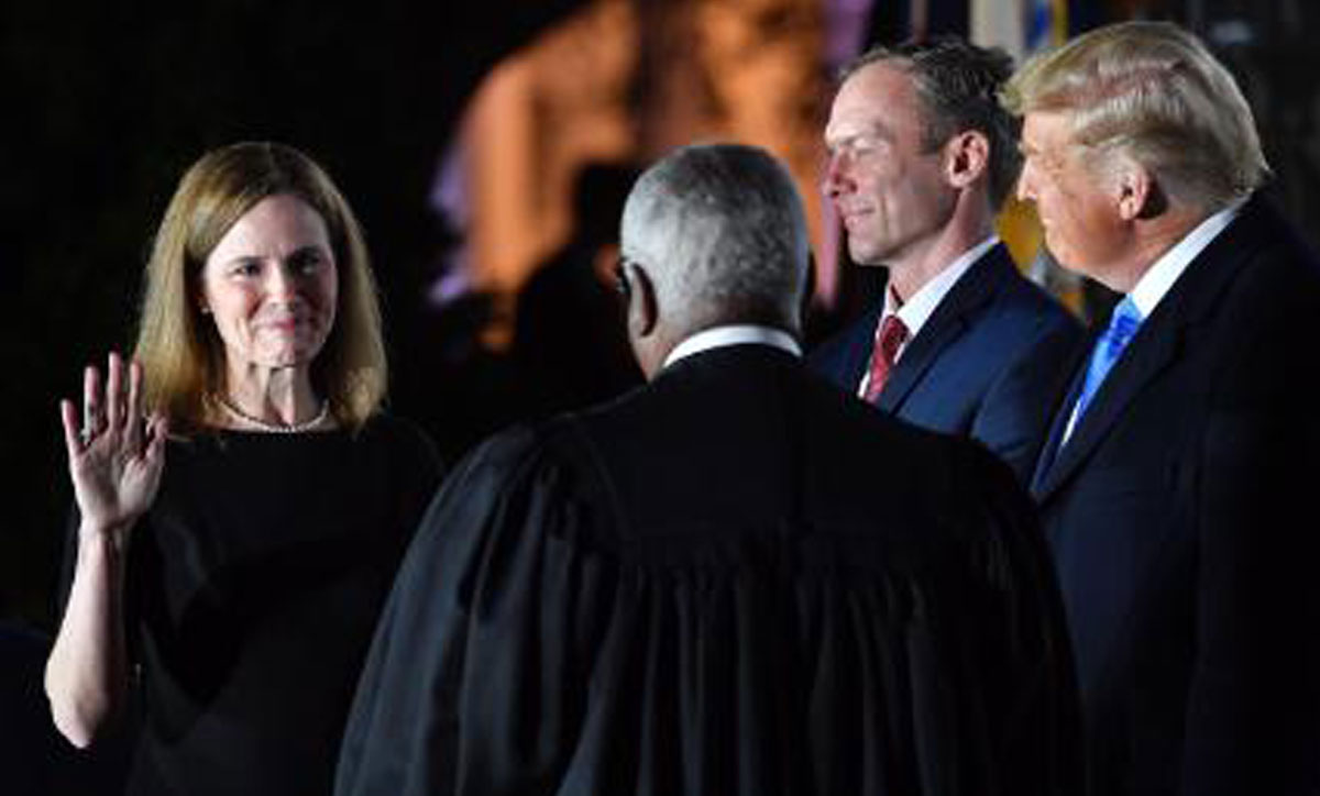 Amy Coney Barrett, left takes the Constitutional Oath administered by Justice Clarence Thomas, Oct. 26, as her husband Jesse and President Trump look on.