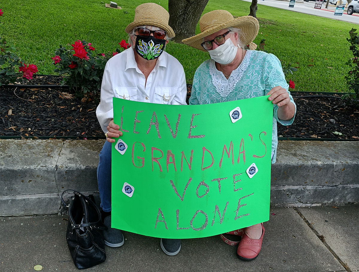 Rally attendees hold signs in protest of voter suppression, April 28. UP photo by Sierra Kondos