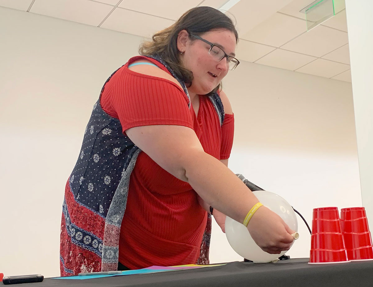 Destiny Turner, junior transfer student, uses balloons to blow down cups during the Week of Welcome "Minute to Win It" event in the Setzer Student Center, Aug. 23. UP photo by Havalyn Crawford