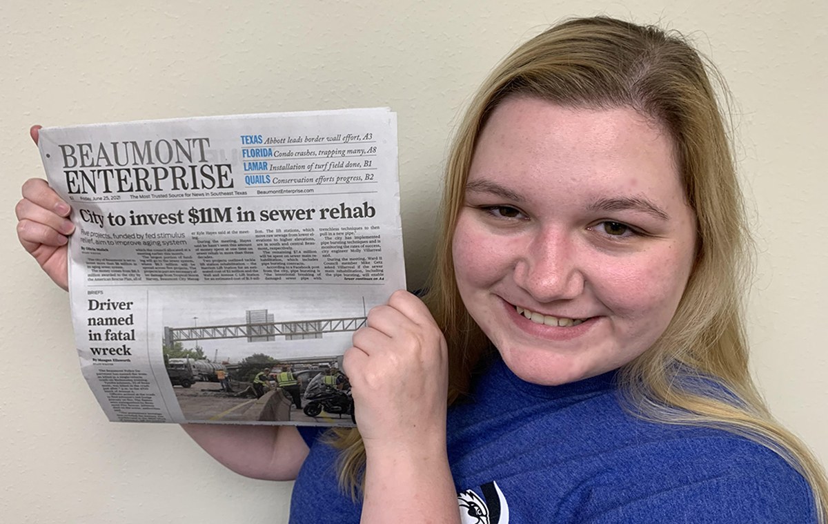 UP editor Olivia Malick poses with her most recent front-page story. UP photo