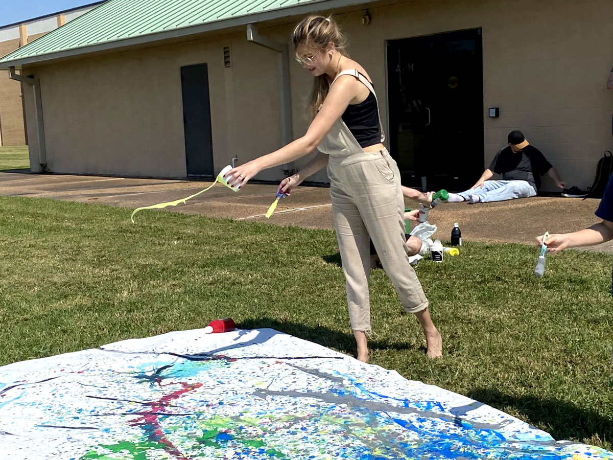 Kendai Hagan, Beaumont senior, splashes paint onto the canvas. UP photo by Maddie Sims.
