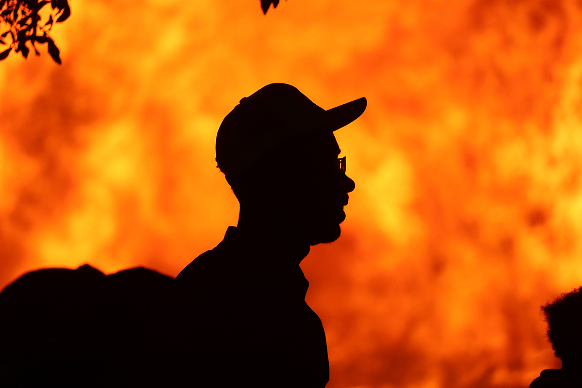 A student is silhouetted against the fire during Lamar University’s Homecoming pep rally and bonfire, Sept. 30, at Spindletop-Gladys City Field. UP photo by Yash Vurukala