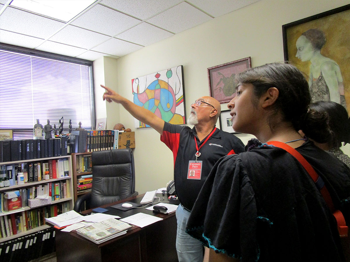 Andy Coughlan (left) gives Hailey Deeds a tour of his office at the University Press. UP photo by Maddie Sims.