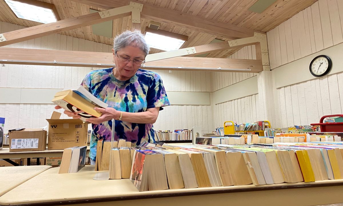 Elaine Wikstrom, president of the Friends of the Library, organizes a row of bools at Miller Library.