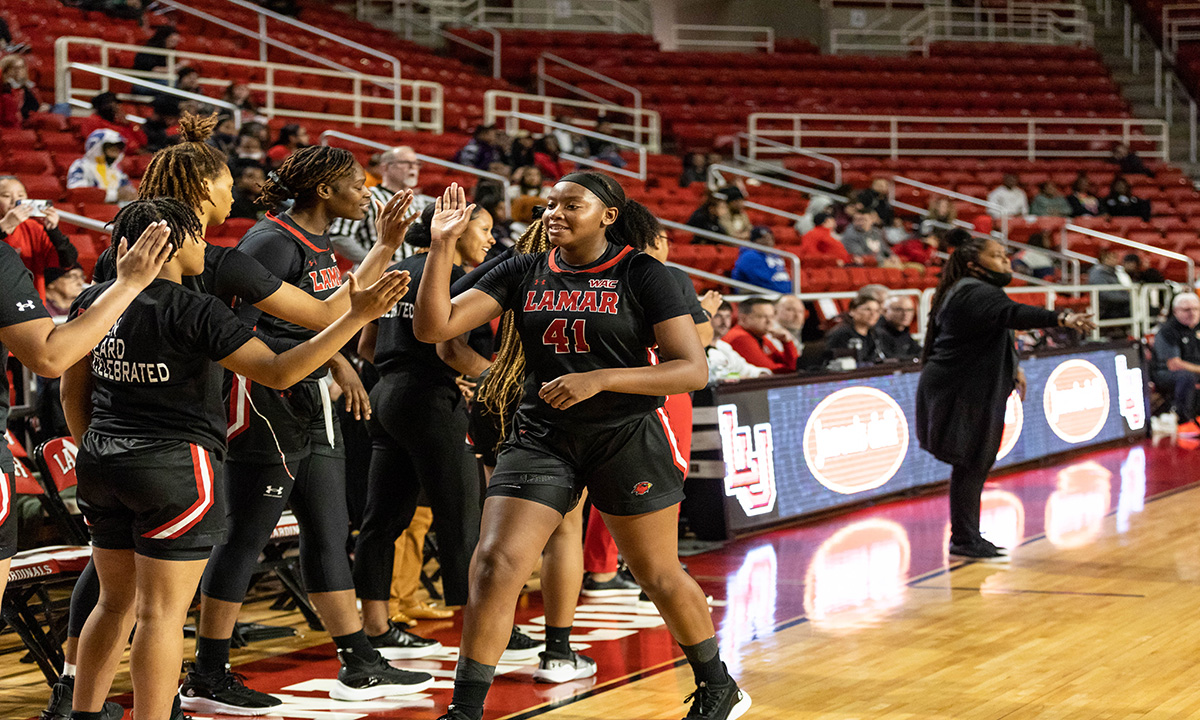 Davis high-fives her teammates after checking out of the game. Photo credit: Brian Quijada.