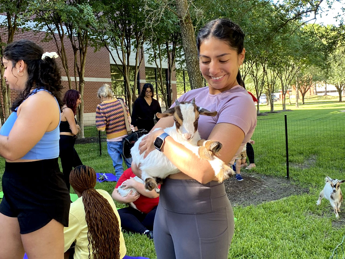 Students hold baby goats at the Goat Yoga Session. UP photo by Maddie Sims.