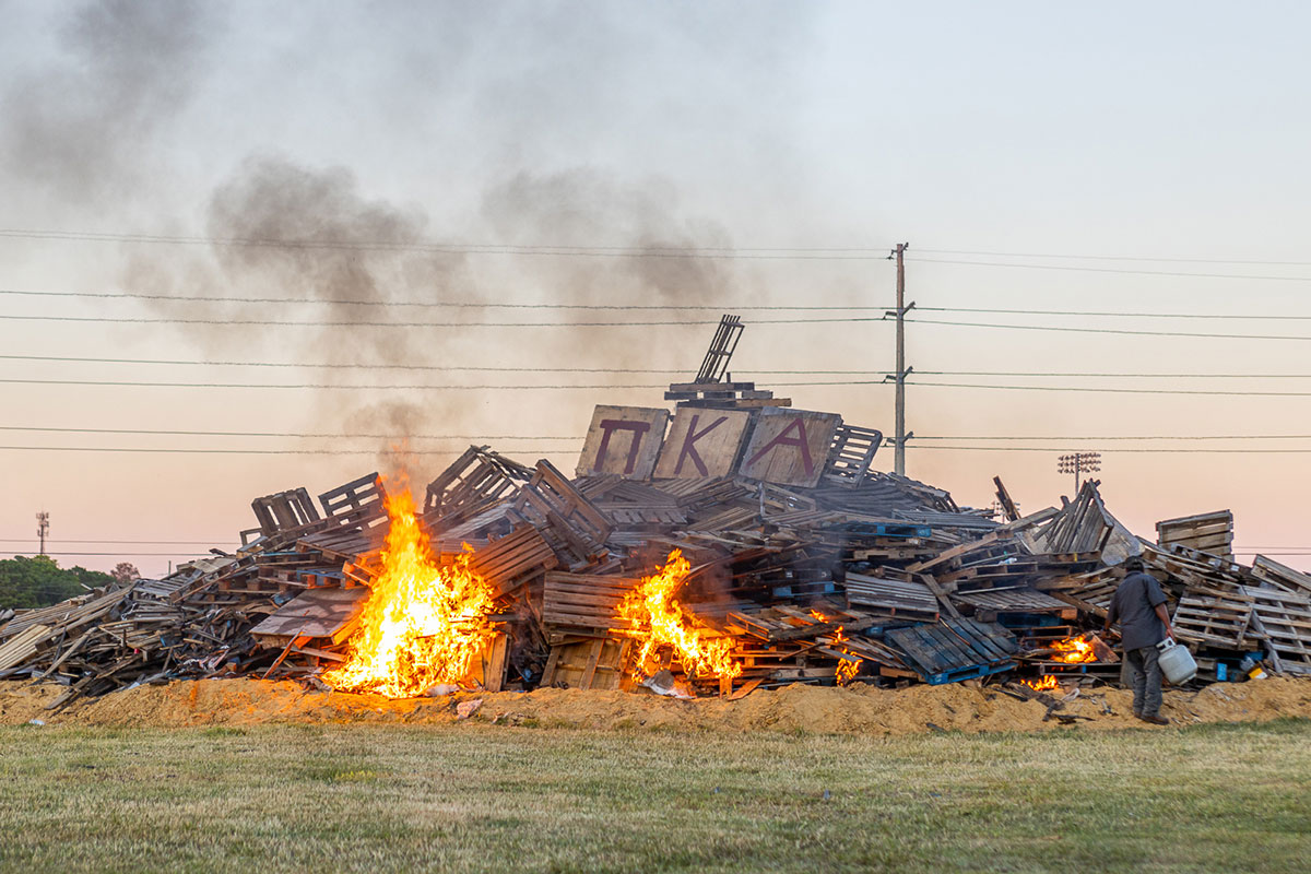 A worker lights the bonfire during the Homecoming pep rally at the Spindletop-Gladys City Field, Sept. 30. UP photo by Brian Quijada.