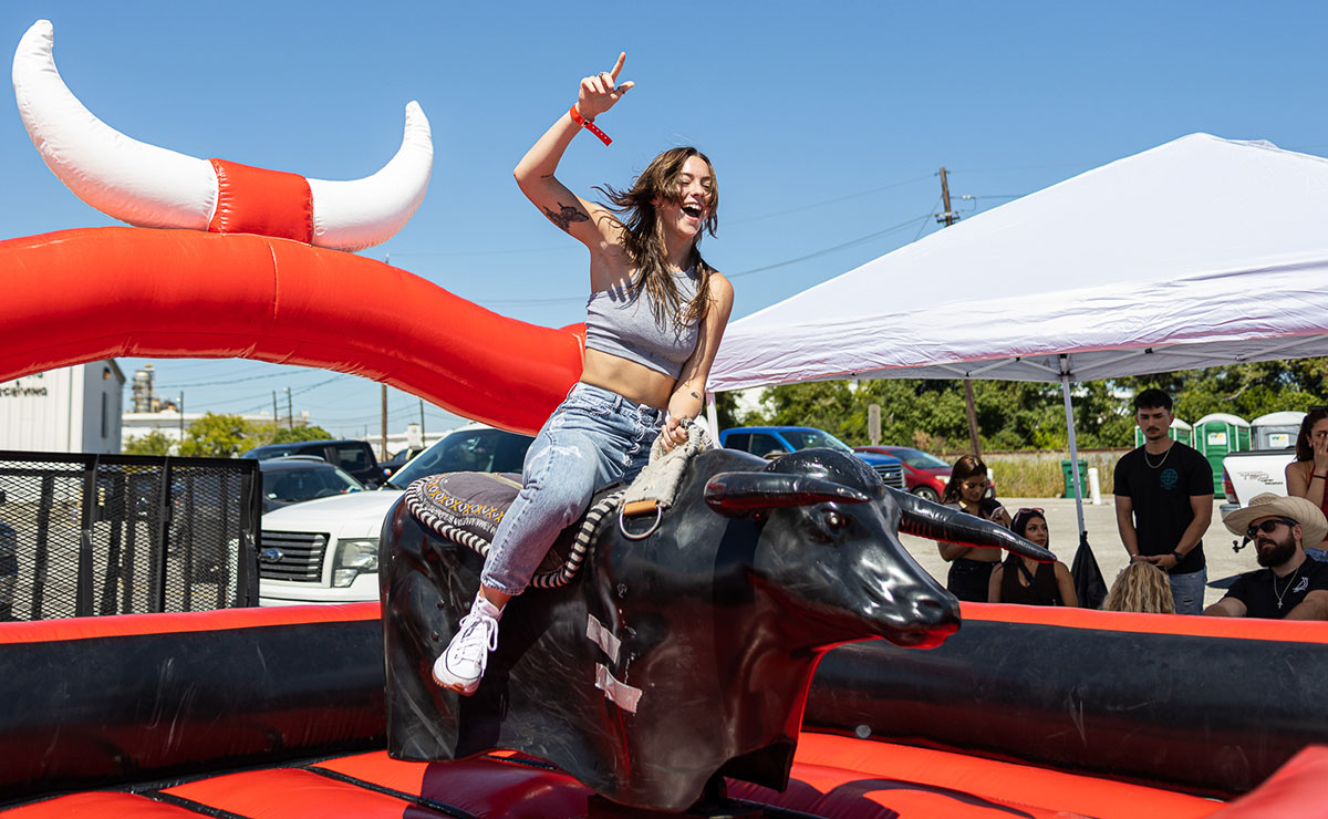 A student rides the mechanical bull while throwing up the “L” during the Homecoming tailgate at the Montagne Center parking lot, Oct. 1. UP photo by Brian Quijada.