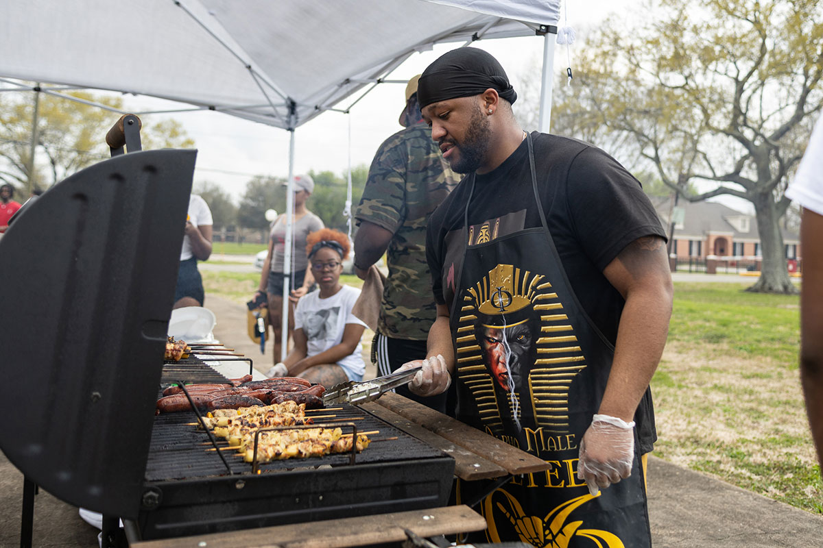 Alpha Phi Alpha member Chase Cotton grills food for the students at the Black History Month Block Party, Feb. 24, at Cardinal Park. UP photo by Brian Quijada.