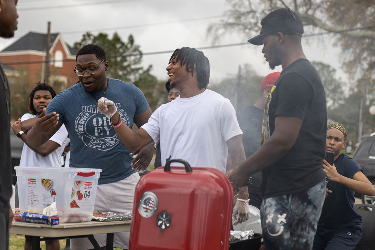 Members of the Man Up organization preparing and grilling food at the Black History Month Block Party, Feb. 24, at Cardinal Park. UP photo by Brian Quijada.