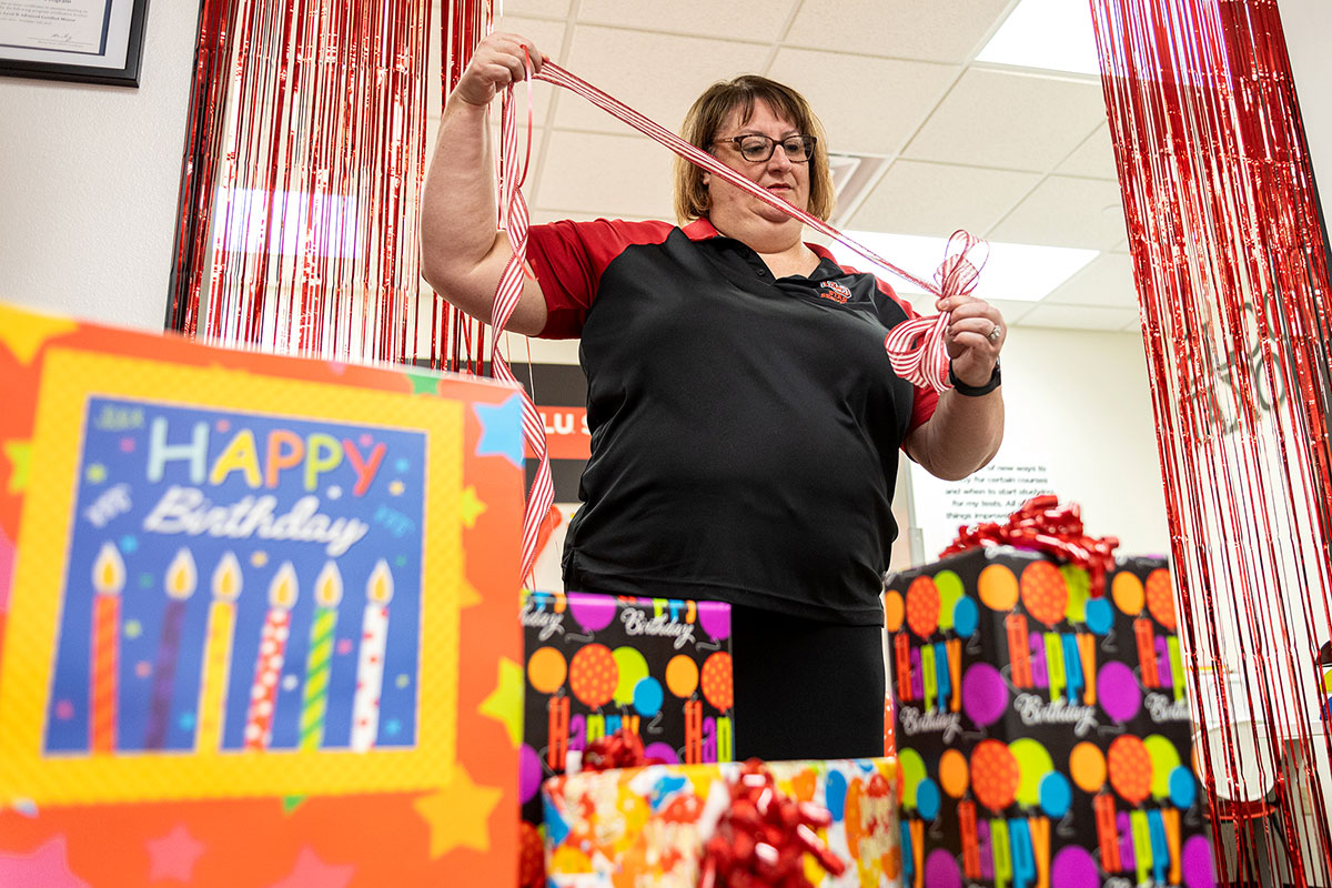STARS director Rachel Hoover decorates "happy birthday" gifts for Lamar University's centennial Homecoming, Oct. 26, in the Communication Building. UP photo by Brian Quijada.