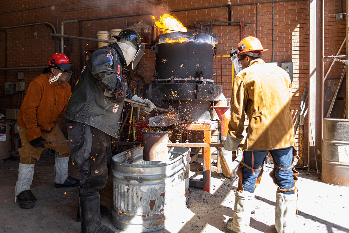 LU art professor Kurt Dyrhaug and staff break the plug on the furnace to release the molten iron as sparks fly out, March 3, at the art foundry. UP photo by Brian Quijada.