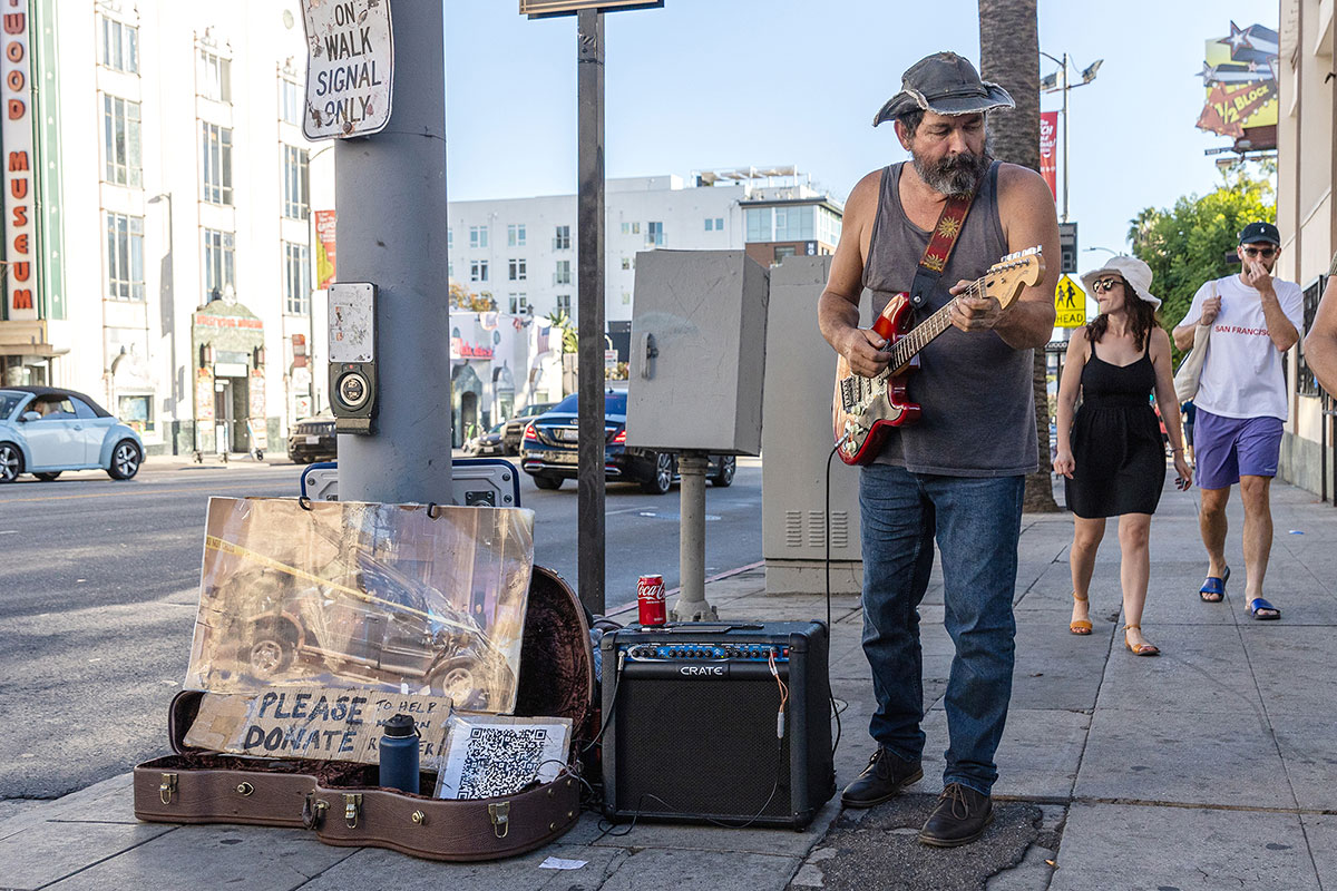 A man plays the guitar for money to help fix his car on Hollywood Boulevard, Los Angeles, Oct. 6. UP photo by Brian Quijada.