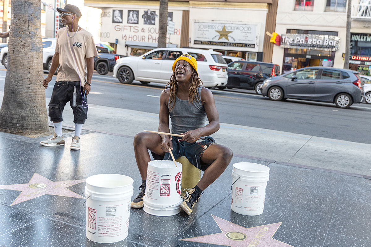 A street drummer yells as he plays the bucket drums on Hollywood Boulevard, Los Angeles, Oct. 6. UP photo by Brian Quijada.