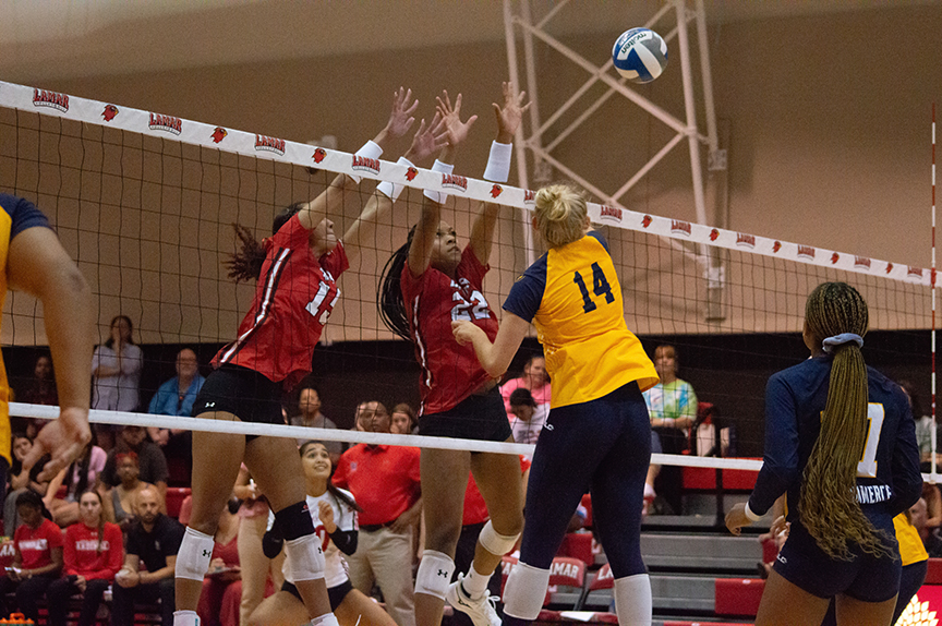 Cardinal outside hitters attempt to block the ball against TAMUCC Lions, Sept. 23, at McDonald’s Gym. UP photo by Allyson Arnold.