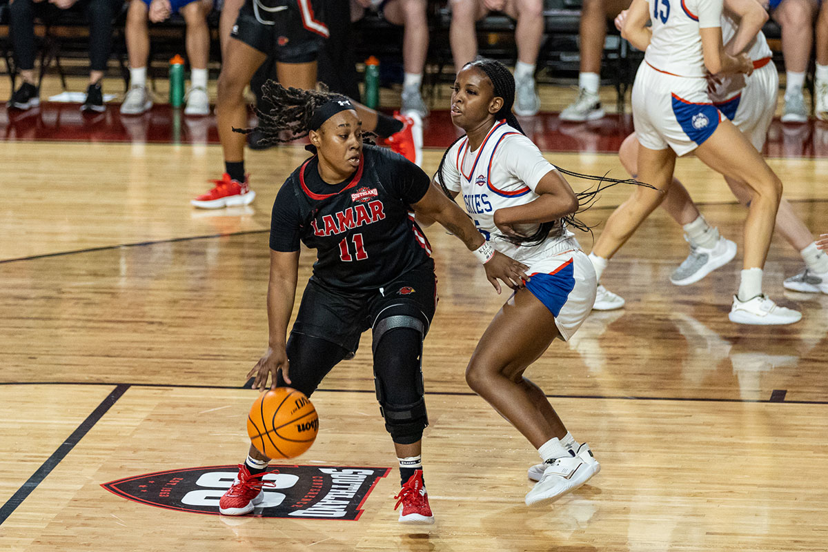 Lamar guard Portia Adams dribbles past HCU defender, Feb. 16, at the Montagne Center. UP image by Brian Quijada.