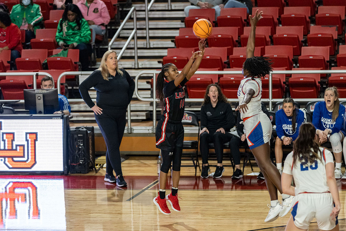 LU guard Malay McQueen shoots a three pointer against a Houston Christian University defender, Feb. 16, at the Montagne Center. UP image by Brian Quijada.