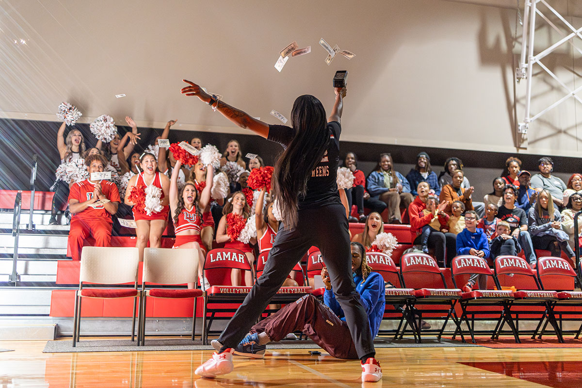 Lady Cardinal forward NJ Weems shoots prop money to the stands during McDonald Mayhem, Oct. 30, in McDonald Gym. UP photo by Brian Quijada.