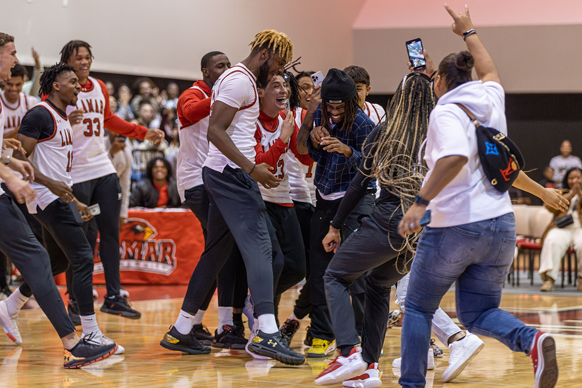 amar basketball players rush the court to surround senior Caillou Collins after he hit a half-court shot to win free concessions for a year during McDonald Mayhem, Oct. 30, in McDonald Gym. UP photo by Brian Quijada.