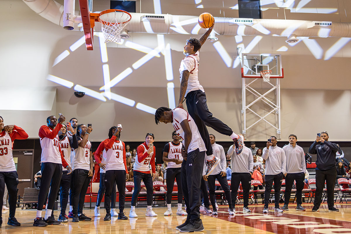 Lamar guard Cody Pennebaker dunks over his teammate, Terry Anderson, as part of the dunk contest at McDonald Mayhem, Oct. 30, at the McDonald Gym. Pennebaker beat teammate B.B. Knight in the contest. UP photo by Brian Quijada.