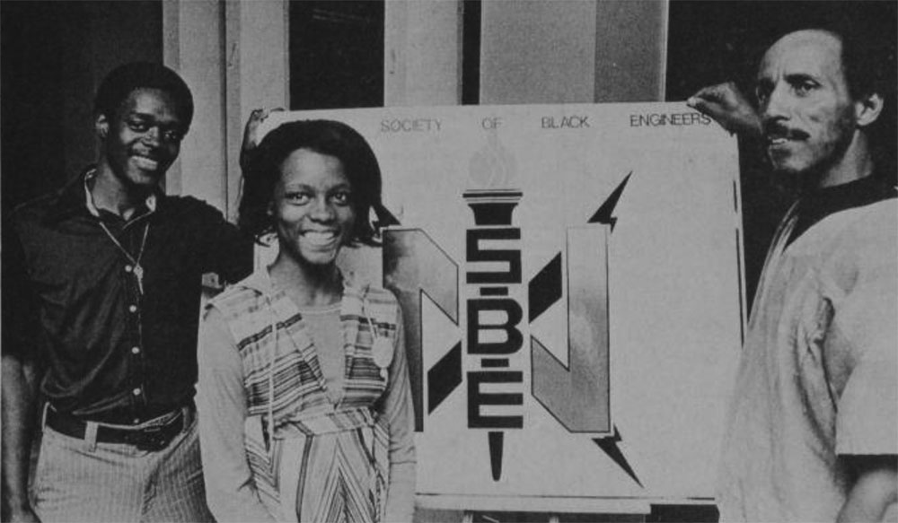 SOCIETY OF BLACK ENGINEERS—James E. Williams and Rita J. Roberts join Dr. Richard L. Price in displaying the logo of their organization, a co-sponsor of the Golden Triangle workshop to recruit minorities in engineering. An expected 150 to 200 area high school science and mathematics teachers will attend. (Photographic Services)