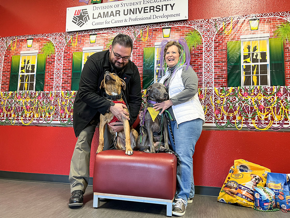 Chief of Police Dr. Héctor Flores holds Derrick for a picture with Joella Harvey and Lace-e during the Mardi Paws pet food drive, Feb. 13, in the Galloway Business Building. UP photo by Brian Quijada.
