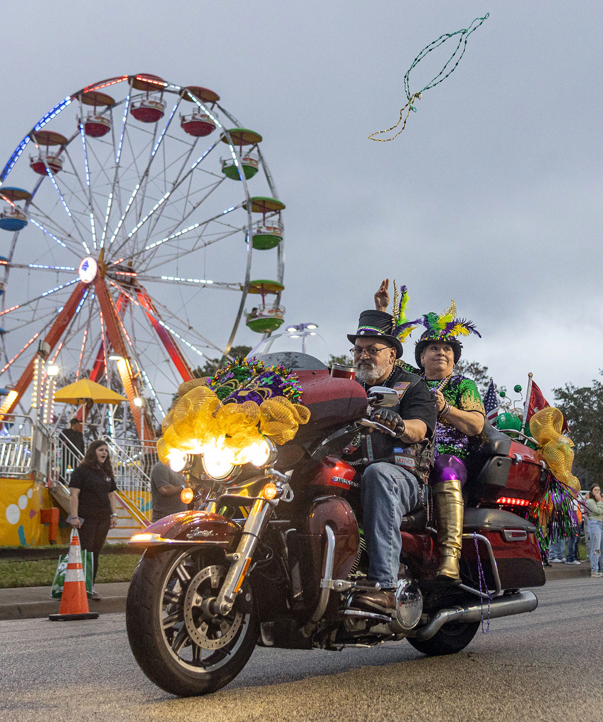 A couple on a motorcycle throw beads to the crowd during the Mardi Gras of Southeast Texas parade, in downtown Beaumont, Feb 10. UP photo by Brian Quijada.
