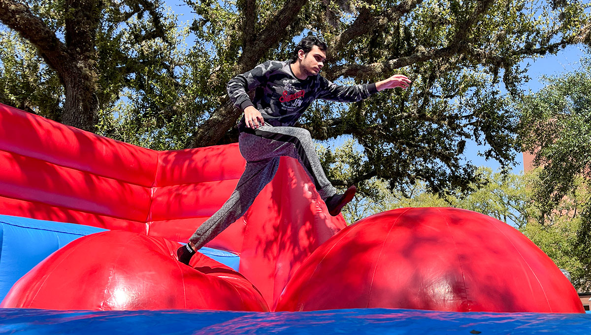 Dallas freshman, Wajdan Ali, runs across the wipeout course during the Lamar University 100 Year Celebration, Mar. 5, in the Dining Hall Lawn. UP photo by Brian Quijada.