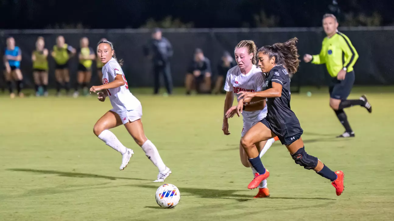 xLU forward Isela Ramirez dibbles past defenders, Aug. 25, at the LU Soccer Complex. Photo cred: LU Athletics