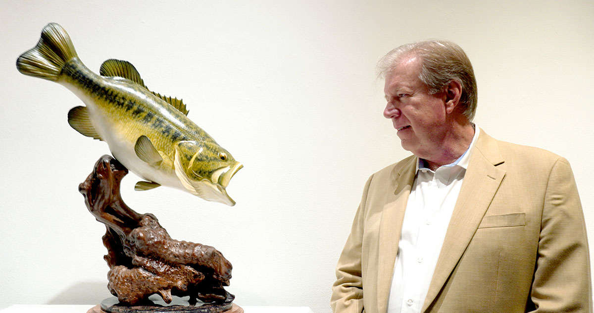 Phil Brannan with his sculpture "Lunker Largemouth Bass 1997-2017." His work is on display at the Art Museum of Southeast Texas through March 17.