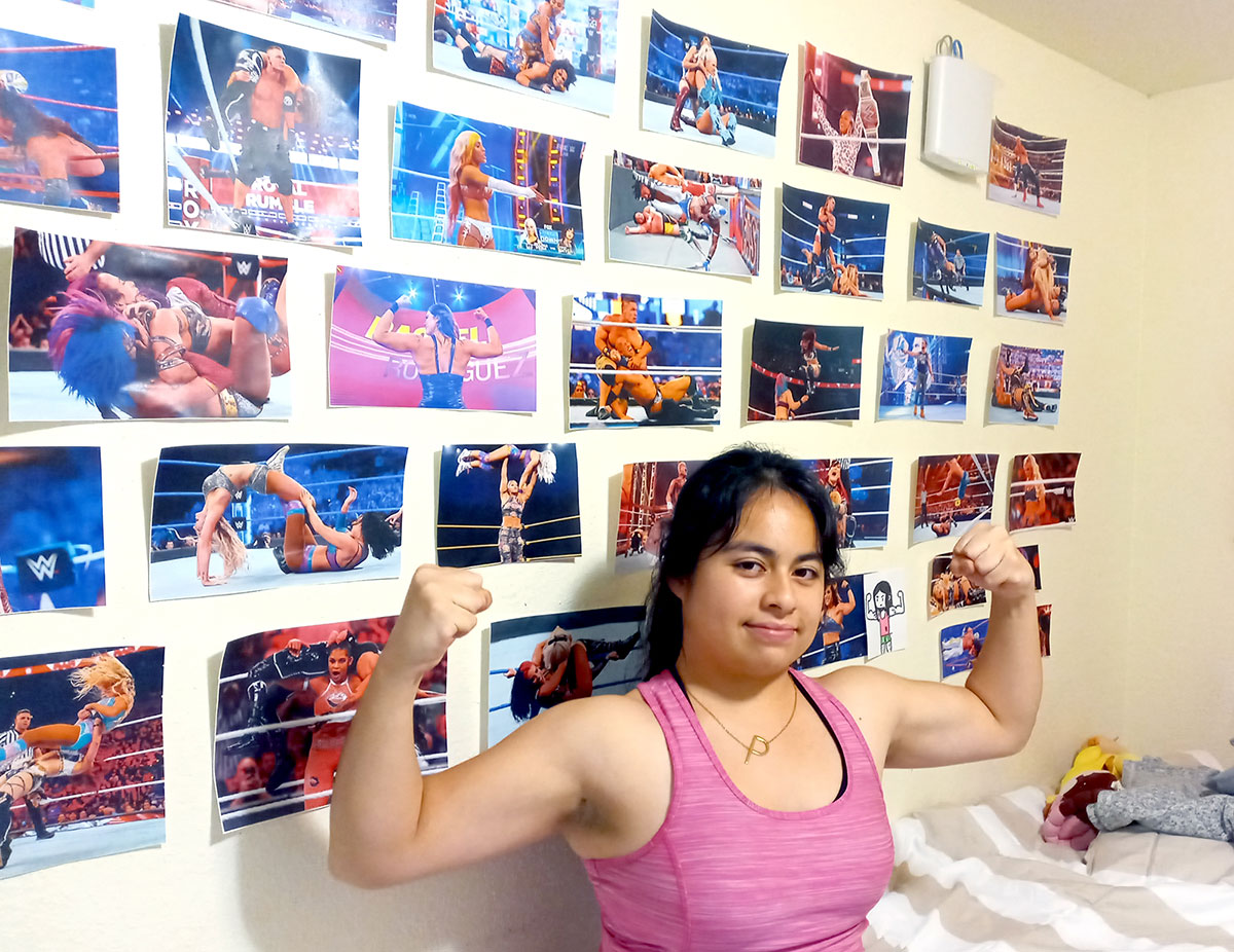 Anahuac freshman Paola Chavez posed with pictures of wrestlers. UP photo by Ana Chavez.