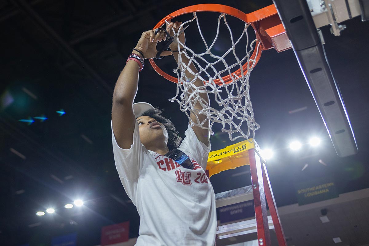 LU guard Sabria Dean cuts the net during the Southland Conference regular season trophy presentation, in the Neches Arena at the Montagne Center, Mar. 7. UP photo by Brian Quijada.