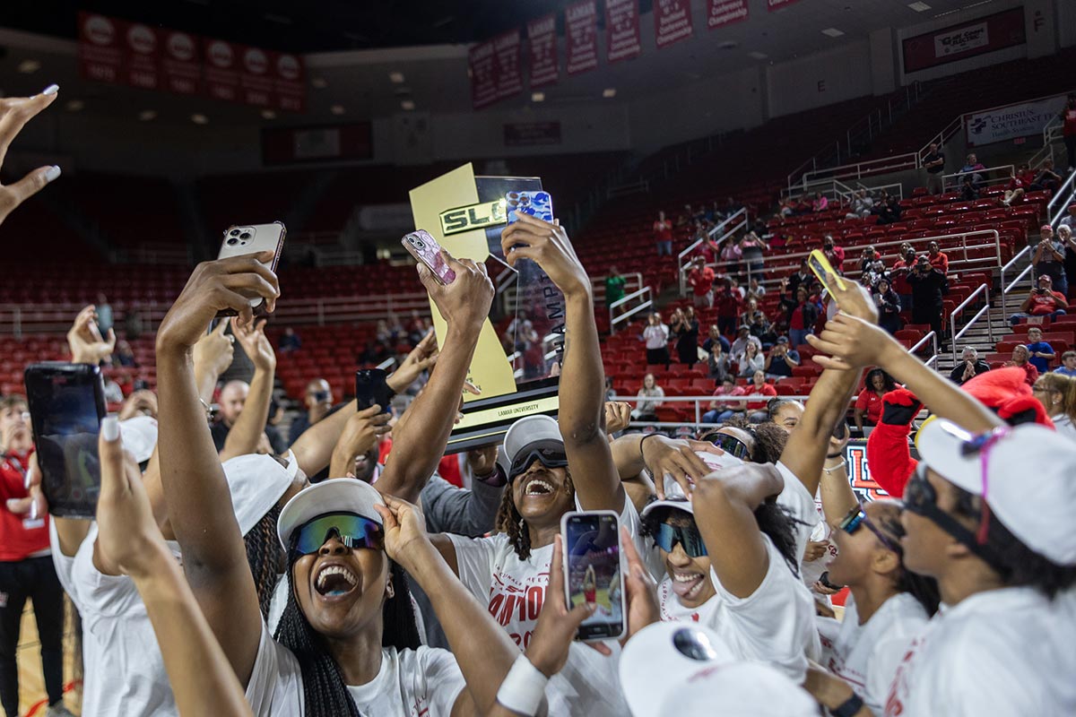 The Lady Cardinals lift the trophy and celebrate during the Southland Conference regular season trophy presentation, in the Neches Arena at the Montagne Center, Mar. 7. UP photo by Brian Quijada.